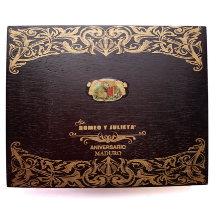 Decorative cigar box with intricate gold patterns and brand logo on a white background