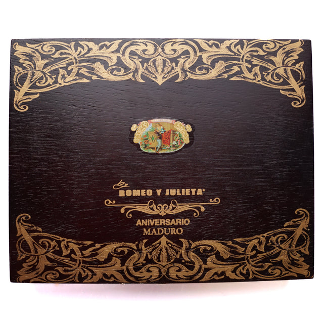 Decorative cigar box with intricate gold patterns and brand logo on a white background